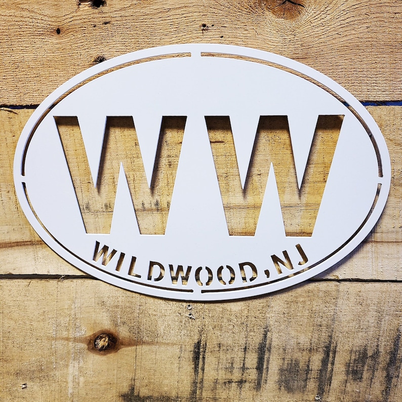 May include: White oval metal sign with the letters "WW" and the text "WILDWOOD, NJ" in a stencil font.