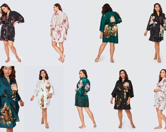 May include: Eight women wearing different floral print robes. The robes are in various colors, including black, white, green, and pink. The robes have long sleeves and are tied at the waist.