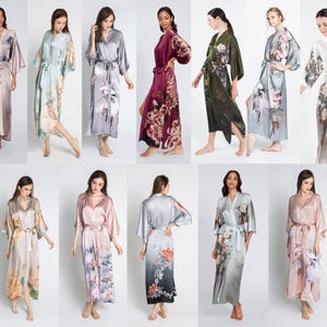 May include: A collection of floor-length satin robes featuring various floral prints and color gradients. Each robe includes wide kimono-style sleeves, a matching waist tie, and a V-neckline. The garments are displayed in multiple colors.