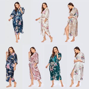 May include: A collection of ten satin robes in various colors including light green, navy blue, white, champagne, purple, dark gray, blue, mauve, dark green, and olive green. Each robe features a floral pattern, three-quarter sleeves, and a tie belt.