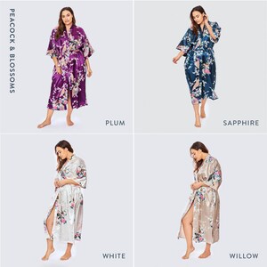 May include: Four satin robes in plum, sapphire, white, and willow colors, each featuring a peacock and blossom print. The robes have a V-neckline, wide three-quarter length sleeves, and a matching tie belt. Text reads PEACOCK & BLOSSOMS.
