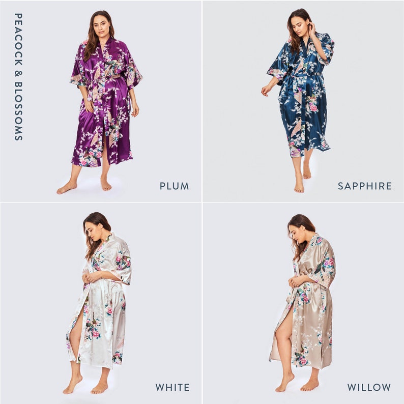 May include: Four satin robes in plum, sapphire, white, and willow colors, each featuring a peacock and blossom print. The robes have a V-neckline, wide three-quarter length sleeves, and a matching tie belt. Text reads PEACOCK & BLOSSOMS.