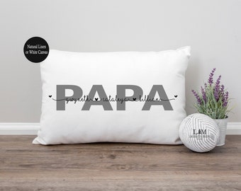 May include: White rectangular pillow with the word "PAPA" in gray, with names and hearts underneath. A small pot of lavender and a decorative ball are next to the pillow. The pillow is made of natural linen or white canvas.