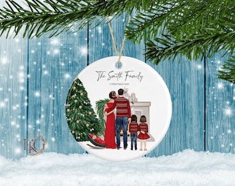 May include: A white ceramic Christmas ornament with a family portrait. The ornament features a family of five in front of a fireplace and Christmas tree. The text "The Smith Family CHRISTMAS 2020" is printed on the ornament.