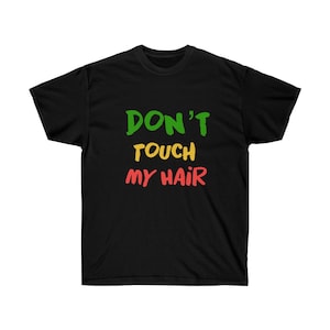 Puede incluir: Camiseta negra con el texto "DON'T TOUCH MY HAIR" en verde, amarillo y rojo.