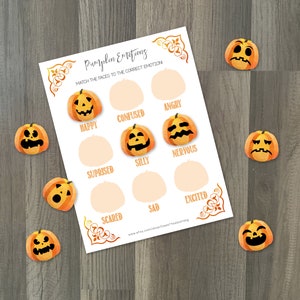 Op de afbeelding: Een educatief spel met Halloween-thema getiteld "Pumpkin Emotions". Het spel bevat een werkblad met pompoengezichten en emotielabels, plus individuele pompoenuitsparingen. De tekst op het werkblad luidt "Match de gezichten met de juiste emotie".