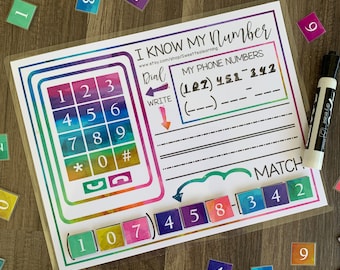 Può includere: Un tappetino educativo colorato con il testo "I Know My Number". Presenta una tastiera telefonica, l'abbinamento dei numeri e una sezione per scrivere i numeri di telefono. Include un pennarello cancellabile a secco e tessere numeriche.