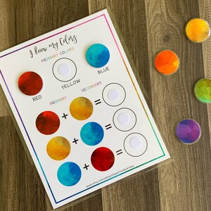 May include: A color learning chart with the text "I know my Colors" and color mixing diagrams. Includes red, yellow, and blue circles, plus secondary colors. Several colorful circular magnets are also present. The Etsy shop URL is visible.