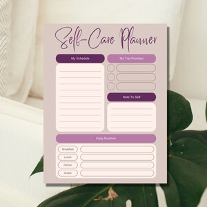 May include: A printable self-care planner with sections for scheduling, top priorities, daily nutrition, and a note to self. The planner has a light purple background with dark purple accents.