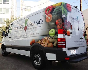 May include: A white delivery van with a colorful graphic of fresh produce, including apples, tomatoes, and broccoli. The van has the text "New Roots Organics" and "Fresh organic produce delivered to your door!" with a phone number and website.