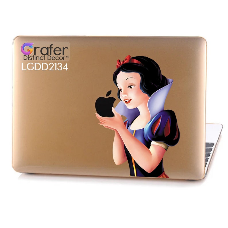 May include: Gold laptop skin with a sticker of Snow White holding a black apple. The sticker has the text "Grafer Distinct Decor" and "LGDD2134".