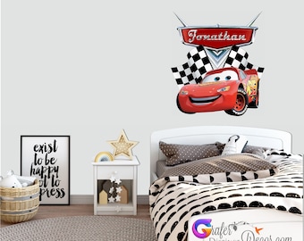 May include: Red race car wall decal with checkered flags and the name "Jonathan" in a silver banner. The decal is on a white wall above a white bed with black and white bedding.