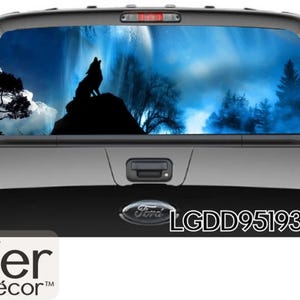 May include: A black pickup truck with a rear window graphic of a wolf howling at the moon in a blue and white forest scene. The graphic also includes the text "LGDD951933-3".