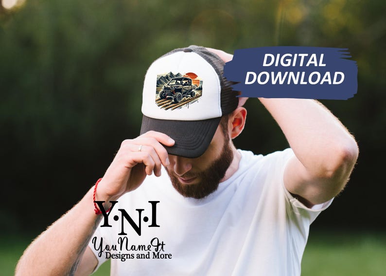 May include: A white and black trucker hat with a graphic of a black off-road vehicle driving through a desert landscape. The hat has a black mesh back and a white front with the text "Y.N.I. You Name It Designs and More".
