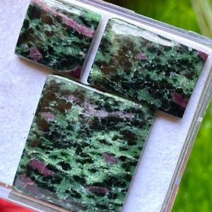 May include: A set of three ceramic mugs with a speckled, matte finish. The mugs are in shades of cream, light gray, and dark gray. Each mug has a simple, minimalist design, perfect for coffee or tea.