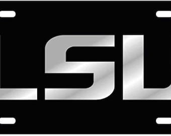 Puede incluir: Placa de matrícula negra con un logotipo LSU plateado.