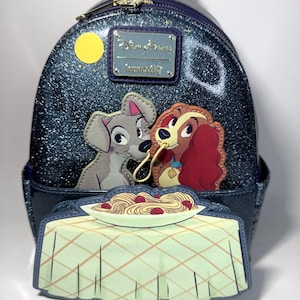 May include: A blue glitter backpack featuring Lady and Tramp sharing spaghetti. The backpack has a yellow moon and a Disney Parks Loungefly logo. The design includes a plate of spaghetti and meatballs.