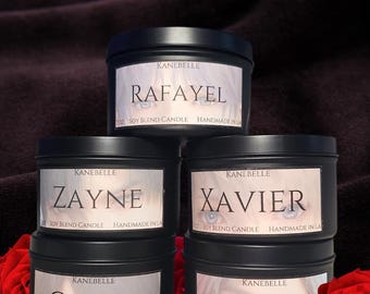 May include: Four black candle jars with white labels. The labels have the brand name "KaneBelle" and the names "Rafayel", "Zayne", "Xavier", and "Caleb" printed on them. The candles are arranged in a stack of two on top of two.