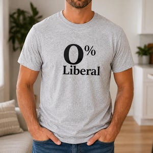 May include: A light gray t-shirt with the text "0% Liberal" in black. The shirt is made of a soft material and has short sleeves. The person is wearing blue jeans.