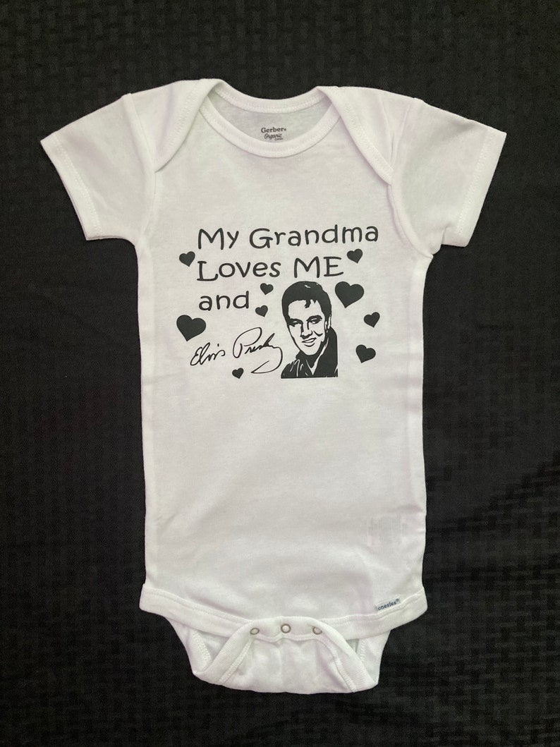May include: White baby onesie with black text that reads "My Grandma Loves ME and Elvis Presley" with a black and white image of Elvis Presley and black hearts.
