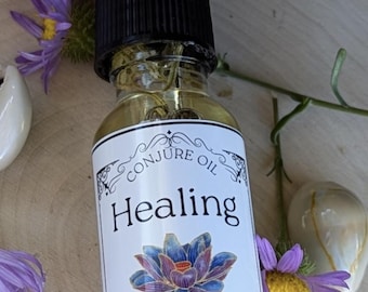 May include: A small glass bottle with a dropper top filled with a clear liquid. The label reads "Conjure Oil Healing" with a lotus flower design and the text "Conjured Moon".