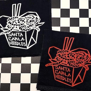 May include: Two black square patches with a white and red graphic of noodles in a takeout box. The text "SANTA CARLA NOODLES" is below the noodles. The bottom patch has the text "SEWSTRANGECONJURINGS".