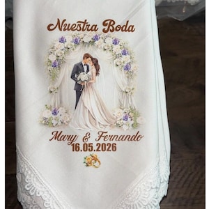 May include: White handkerchief with a lace trim, featuring a printed wedding design. The design includes the text "Nuestra Boda", a couple under a floral arch, and the names "Mary & Fernando" with the date "16.05.2026".