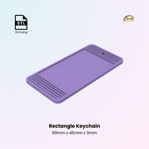 Może przedstawiać: Fioletowy prostokątny brelok do kluczy z otworem na kółko do kluczy. Brelok ma wymiary 90 mm x 45 mm x 3 mm.