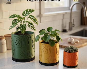 May include: Three decorative planters in green, yellow, and orange, each with a leaf pattern. The planters hold green plants and succulents. The words "Digital Download" are in the image.