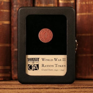 May include: A red World War II ration token with the text "OPA 1 RED POINT" in a black display case. The case has a label that reads "OFFICE OF PRICE ADMINISTRATION WORLD WAR II RATION TOKEN United States, 1942-1945".