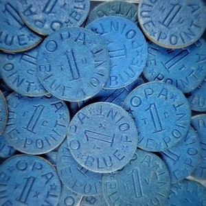 May include: A close-up of a pile of blue poker chips with the words "1 Blue Point" printed on them.
