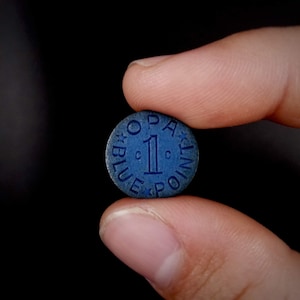 May include: A blue poker chip with a white star design and the text "One Blue Point" in a circle.