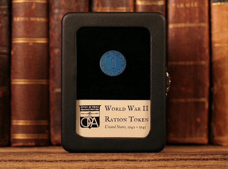 May include: A blue World War II ration token in a black display case with the text "World War II Ration Token United States, 1942-1945" and the Office of Price Administration (OPA) logo.