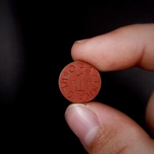 May include: A red circular token with the text "One Red Point" printed on it.