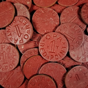 May include: Close-up of a pile of red game tokens with the text "1 RED POINT" on each token.