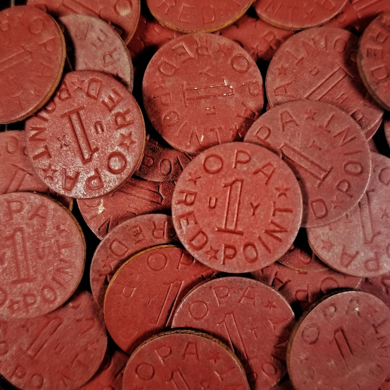 May include: Close-up of a pile of red game tokens with the text "1 RED POINT" on each token.
