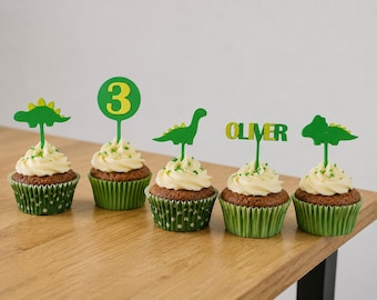 Decorazioni personalizzate per cupcake a tema dinosauri, ideali per feste a tema dinosauri con nome e numero.