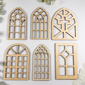 Puede incluir: Seis recortes de marcos de ventanas de madera sin terminar en varios estilos. Los marcos son todos arqueados y tienen diferentes patrones de paneles.