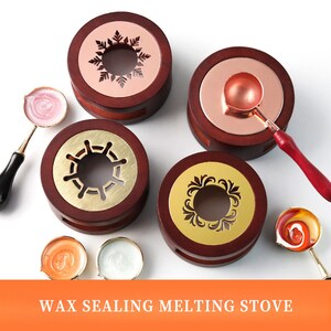 May include: Four wooden wax sealing melting stoves with different decorative designs. Each stove has a small metal pot for melting wax and a spoon for scooping wax. The stoves are on a white background.