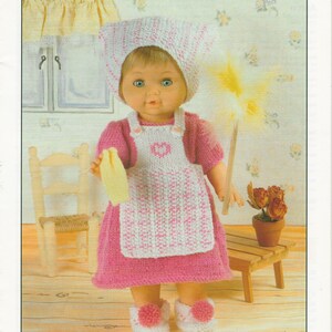May include: A doll wearing a pink dress, white and pink apron, and matching bonnet. The doll holds a yellow cloth and a feather duster. The text "A busy day ahead" is at the bottom of the image.