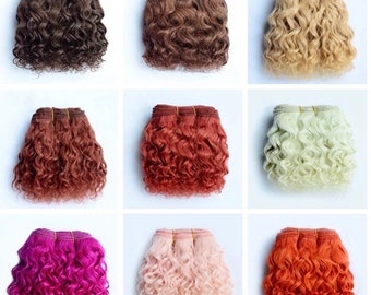 May include: Nine bundles of curly hair extensions in various colors, including brown, auburn, blonde, green, purple, pink, and orange. Each bundle is tied with a thin, light-colored band. The hair has a natural, wavy texture.
