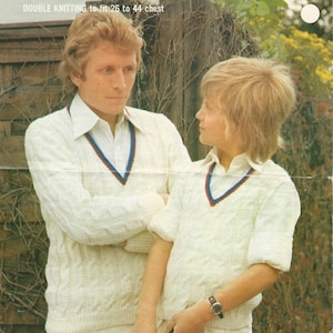 May include: Vintage knitting pattern cover featuring two people wearing matching cream-colored cricket sweaters with blue and red trim. The word "Robin" is at the top, with text indicating the pattern is for double knitting and fits a 26 to 44-inch chest.