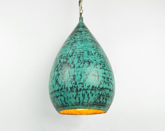 May include: A teal blue pendant light fixture shaped like a teardrop with a gold interior. The light fixture has a textured surface.