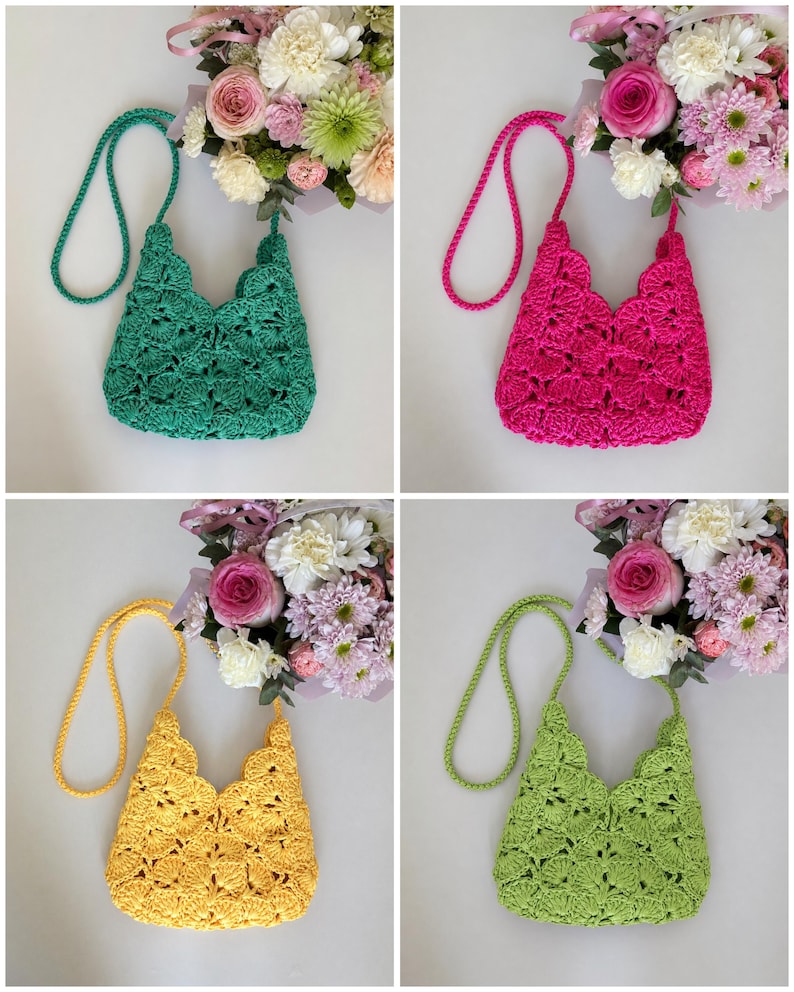 May include: A collection of four crochet bags in emerald green, hot pink, yellow, and lime green. Each bag features a scalloped shell pattern, a matching braided shoulder strap, and a scalloped top edge, displayed alongside a bouquet of flowers.