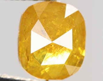 May include: A bright yellow, faceted, cushion-cut diamond.