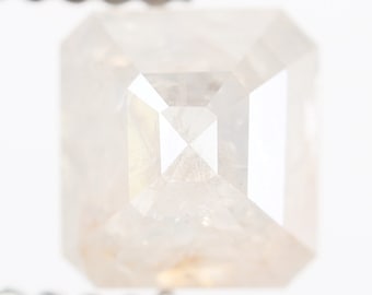 May include: A clear, faceted, rectangular, light brown diamond gemstone.