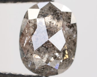 May include: A gray, faceted, oval-shaped diamond with a rough, natural finish.