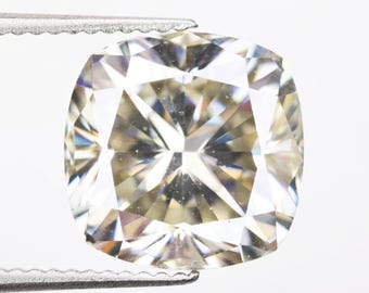 May include: A clear, faceted, cushion-cut gemstone with a brilliant sparkle.