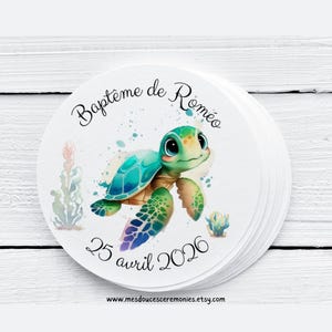 Peut inclure: Une pile d'autocollants ronds avec une illustration à l'aquarelle d'une tortue de mer de dessin animé avec une carapace verte et turquoise. Le texte "Baptême de Roméo" et "25 avril 2026" est imprimé sur l'autocollant.