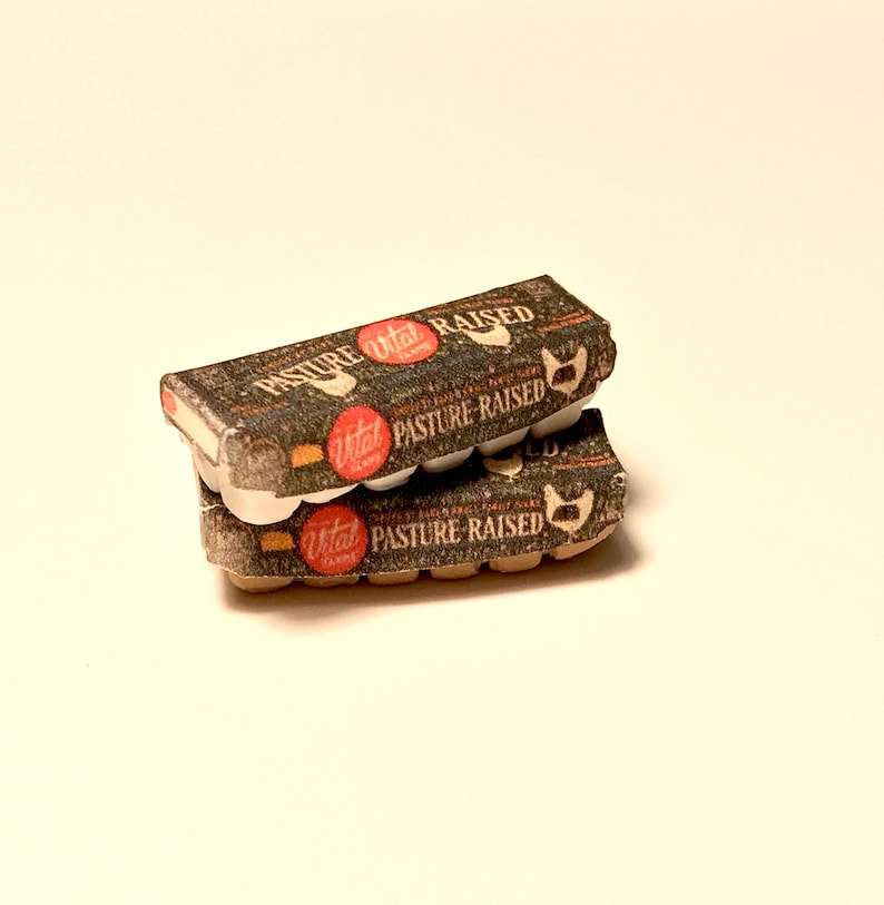 May include: Two cartons of Vital Farms pasture-raised eggs. The cartons are stacked on top of each other. The top carton is brown with white text and a red circle with the Vital Farms logo. The bottom carton is brown with white text and a red circle with the Vital Farms logo.